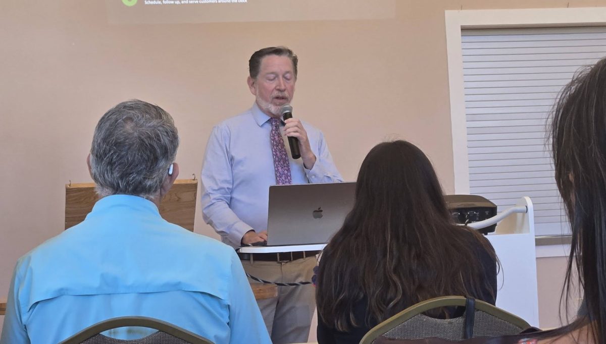 Speaker presenting with microphone at a Lunch and Learn